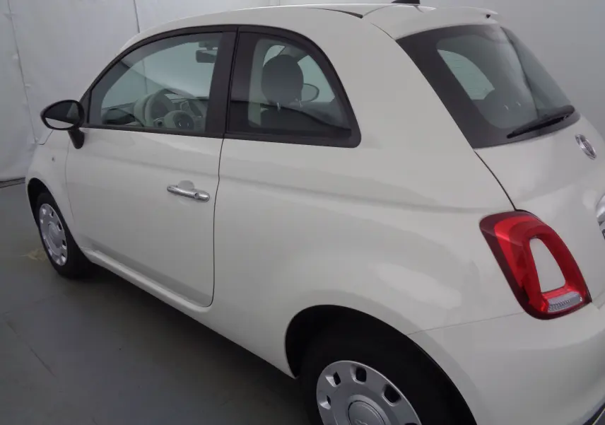 Vue 3/4 arrière côté gauche d'une FIAT 500 blanc gelato, compacte avec feux arrière rouges et jantes acier.