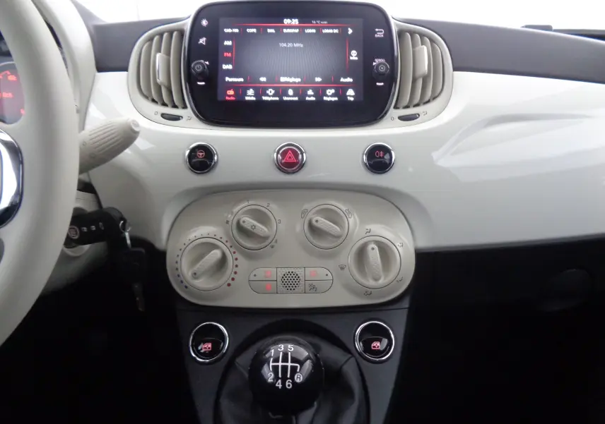 Tableau de bord blanc gelato de Fiat 500 1.0 Hybrid 2023 avec écran tactile et levier de vitesses manuel en vue frontale.