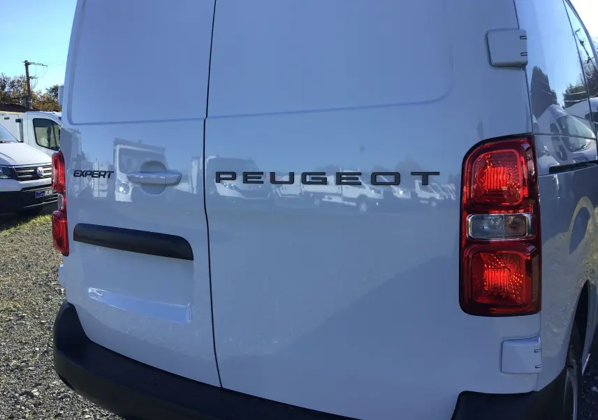 Vue arrière droite d'un fourgon blanc Peugeot Expert 2024 avec logo et feux rouges visibles.