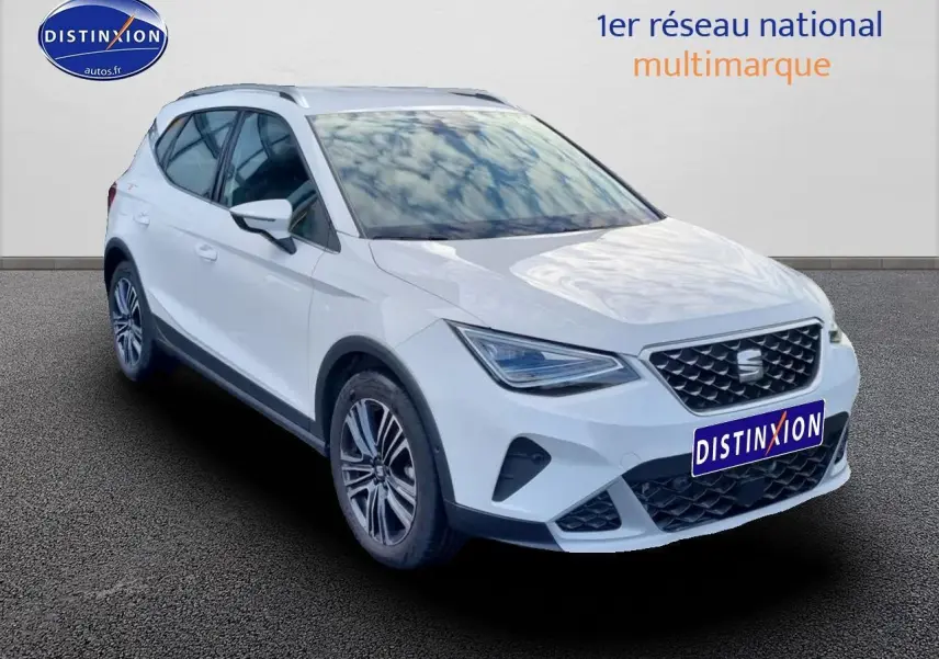 SEAT Arona blanc en vue 3/4 avant droit avec jantes alu 17 pouces et barres de toit visibles