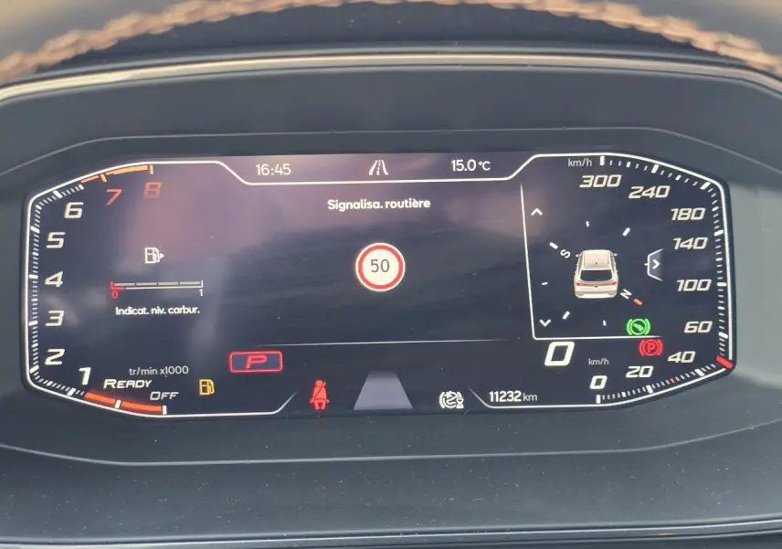 Affichage numérique du tableau de bord de la CUPRA Leon Sportstourer 2024, indiquant la vitesse, régime moteur et signalisation routière.