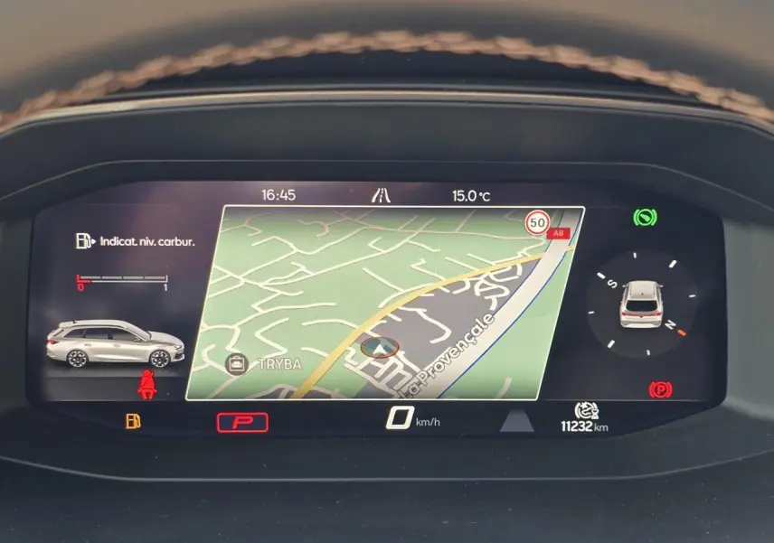 Affichage numérique du tableau de bord du CUPRA Leon Sportstourer blanc Nevada, montrant la navigation et l'état du véhicule.