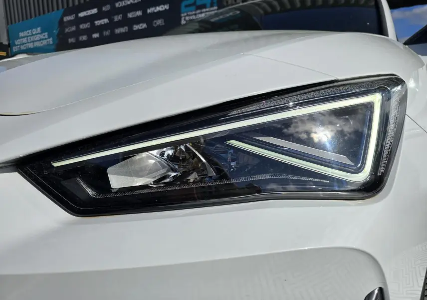 Gros plan sur le phare avant droit LED d'une CUPRA Leon Sportstourer blanc Nevada métallisé 2024.