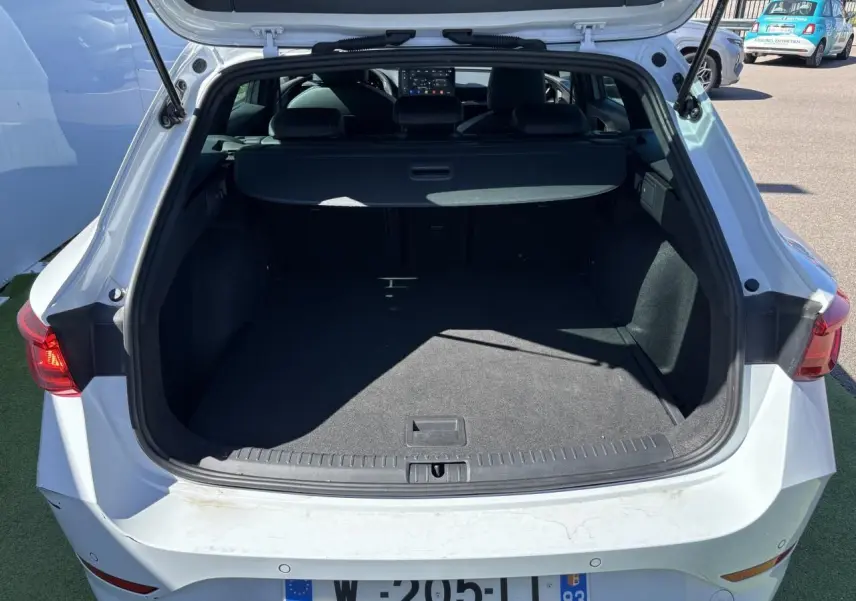 Vue arrière du coffre ouvert d'une CUPRA Leon Sportstourer blanc Nevada, avec feux arrière LED visibles.