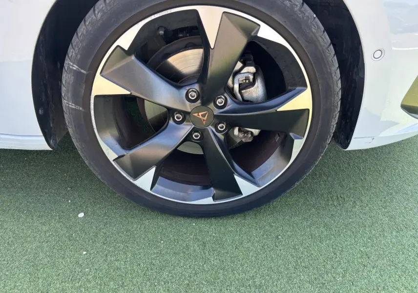 Gros plan sur la jante alliage 18 pouces noire et argentée du côté avant droit d'une CUPRA Leon Sportstourer blanc Nevada.