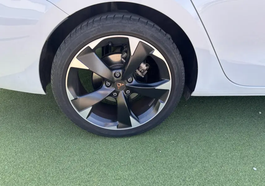 Gros plan sur la roue arrière droite d'une CUPRA Leon Sportstourer blanche avec jante alliage 18 pouces bicolore.