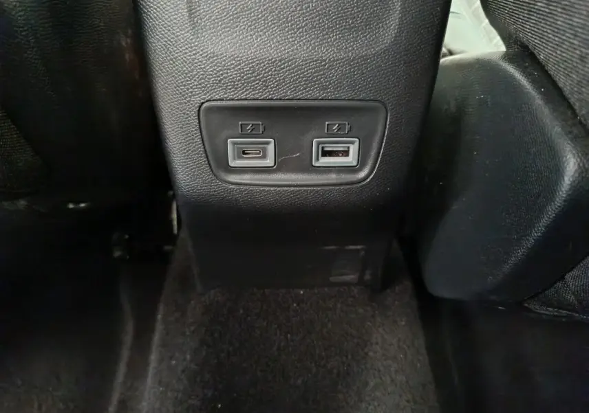 Prise USB Type-C et USB Type-A pour recharge à l'arrière d'un Peugeot 208 gris clair, intérieur noir.