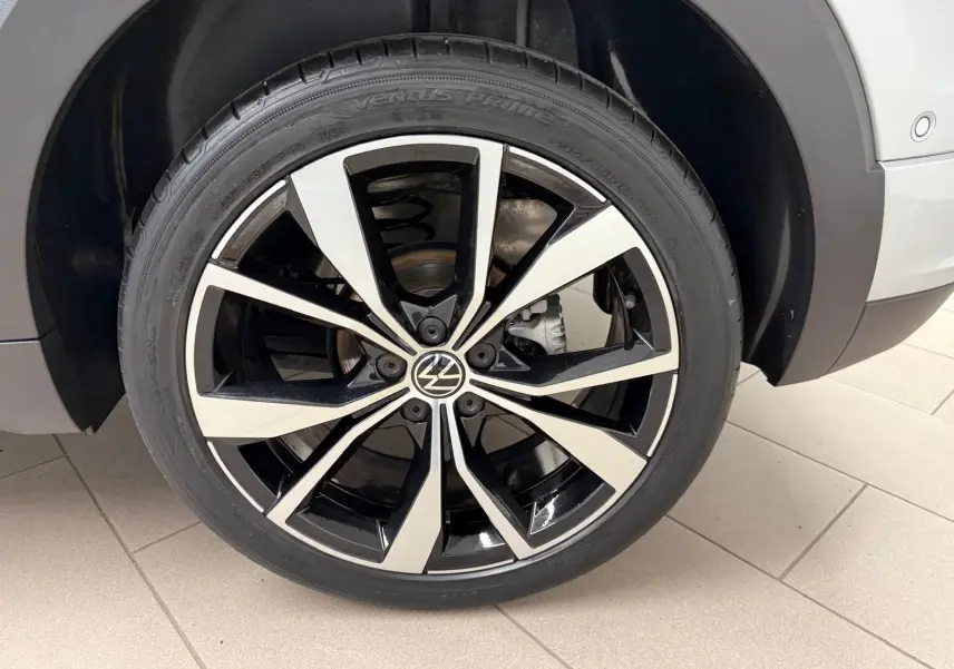 Gros plan sur la jante alliage 18'' bicolore noir et argent du Volkswagen T-Cross 1.5 TSI R-Line couleur Reflet d'Argent.