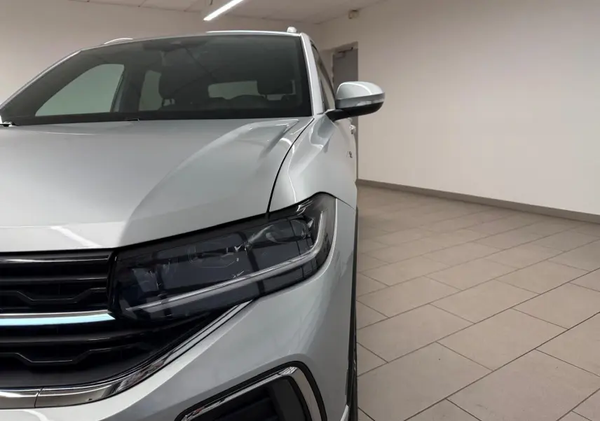 Gros plan sur l'avant droit du Volkswagen T-Cross 1.5 TSI R-Line en peinture métallisée Reflet d'Argent, avec phares Matrix LED.