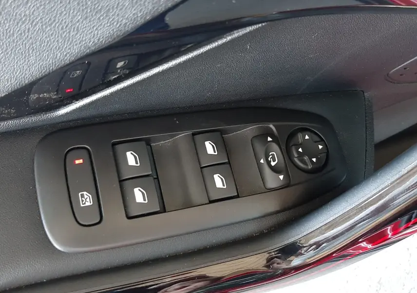 Commande des vitres et rétroviseurs côté gauche sur porte rouge métallique d'une Peugeot 2008 GT Line 2019.