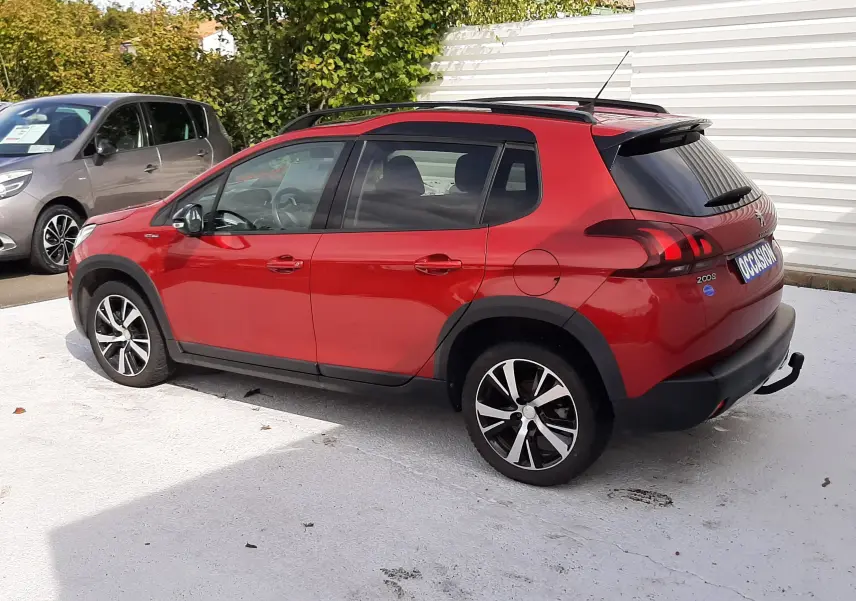 Peugeot 2008 rouge Ultimate Metal vue de profil côté droit, avec barres de toit et jantes alliage noires.
