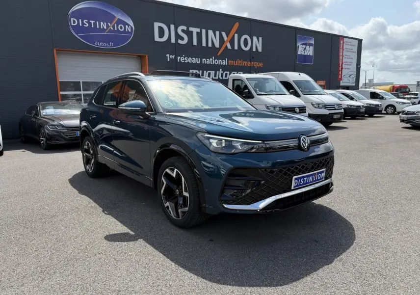 Volkswagen Tiguan 2024 bleu métallisé en 3/4 avant droit avec jantes R-Line et calandre noire distinctive.