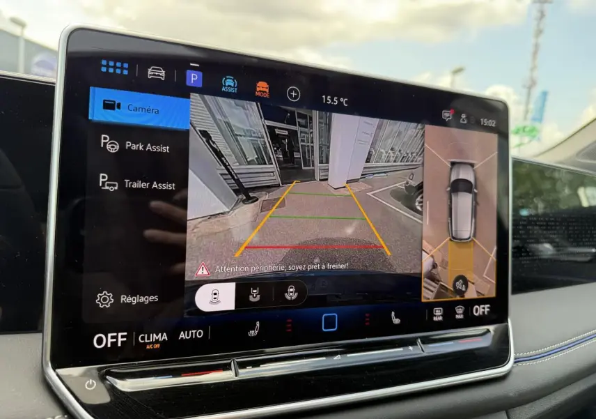 Écran tactile intérieur du Volkswagen Tiguan 2024 affichant l'assistance au stationnement avec vue caméra et plan 360° du véhicule.
