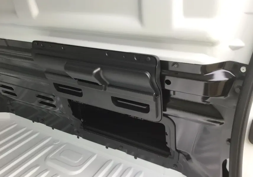 Détail de la cloison avec trappe de chargement longue ouverte sur le côté gauche du Renault Trafic Fourgon blanc.