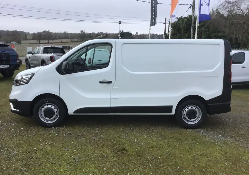 Vue de profil côté gauche d’un Renault Trafic Fourgon blanc 2025 avec porte latérale coulissante et jantes acier.