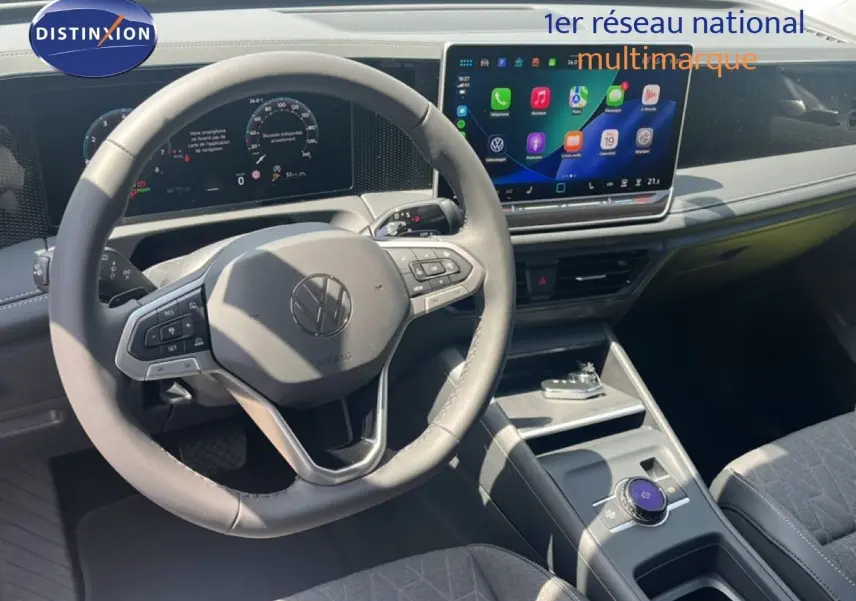 Vue intérieure du volant et tableau de bord du Volkswagen Tiguan 2026 noir avec écran tactile central et commandes au volant.