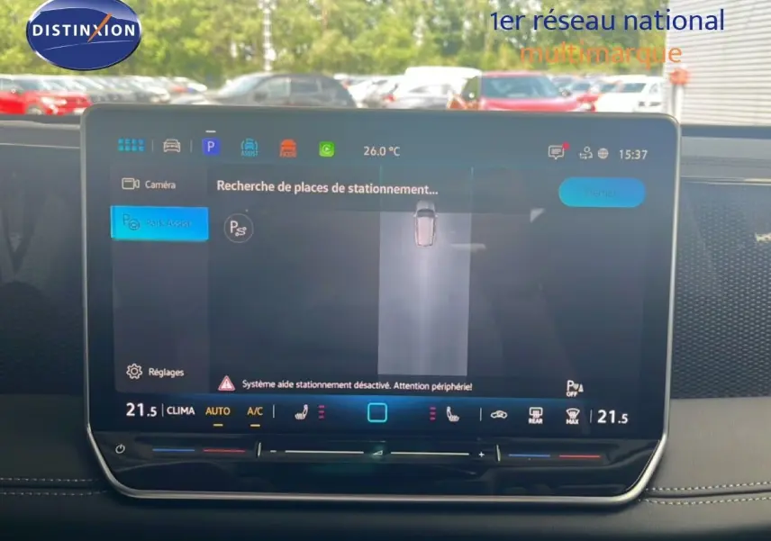 Écran tactile central du Volkswagen Tiguan 2026 affichant l'assistance au stationnement, intérieur noir visible en arrière-plan.
