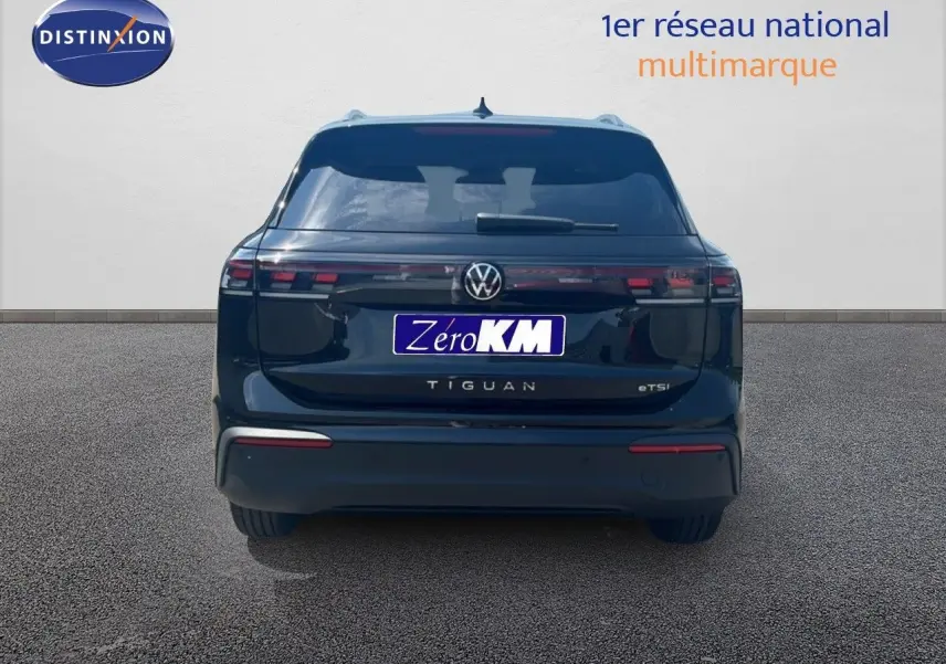 Vue arrière d’un Volkswagen Tiguan noir Grenadilla métallisé, avec feux arrière LED et logo central visible.