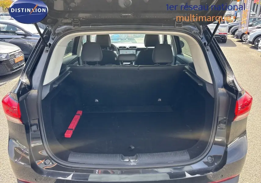 Vue arrière du coffre ouvert du MG ZS 1.5L Hybrid+ 197ch Luxury en Pebble Black Metal, intérieur spacieux et noir.