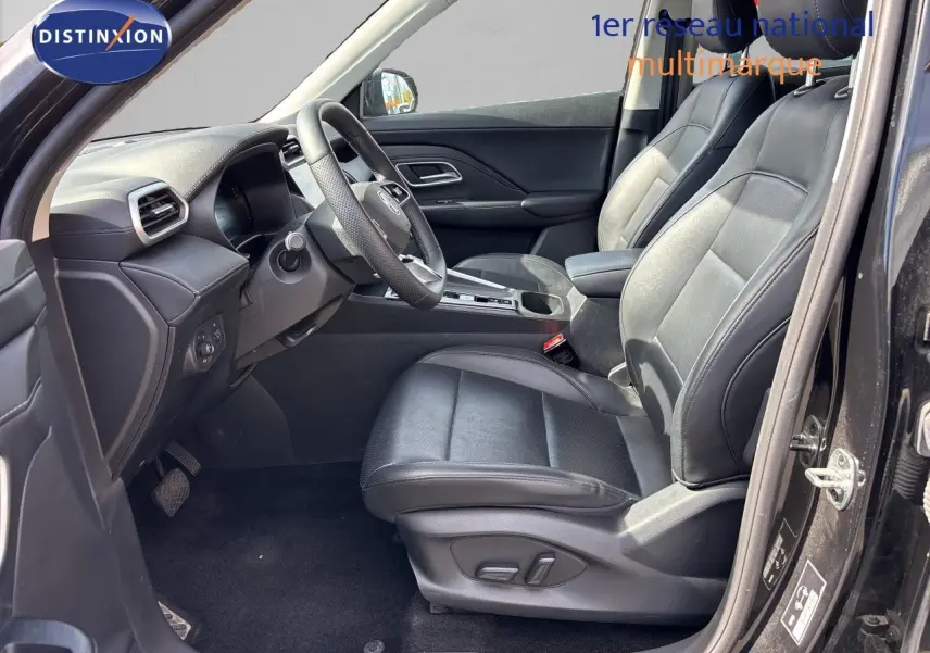 Vue intérieure côté conducteur du MG MOTOR ZS 1.5L HYBRID+ 197CH LUXURY 2025 en Pebble Black, sièges cuir noirs et volant multifonction.