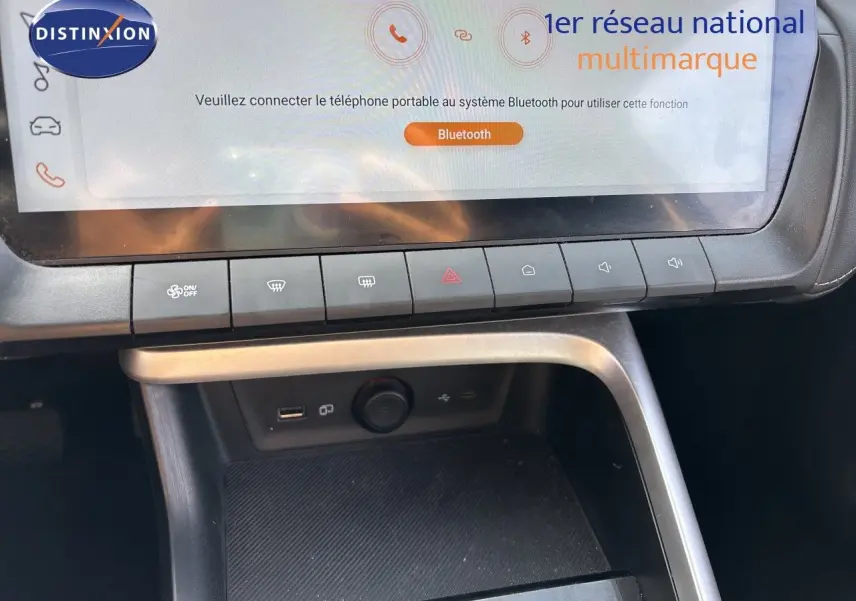 Détail de la console centrale du MG ZS 1.5L Hybrid+ 2025 avec écran tactile et rangements en plastique noir.