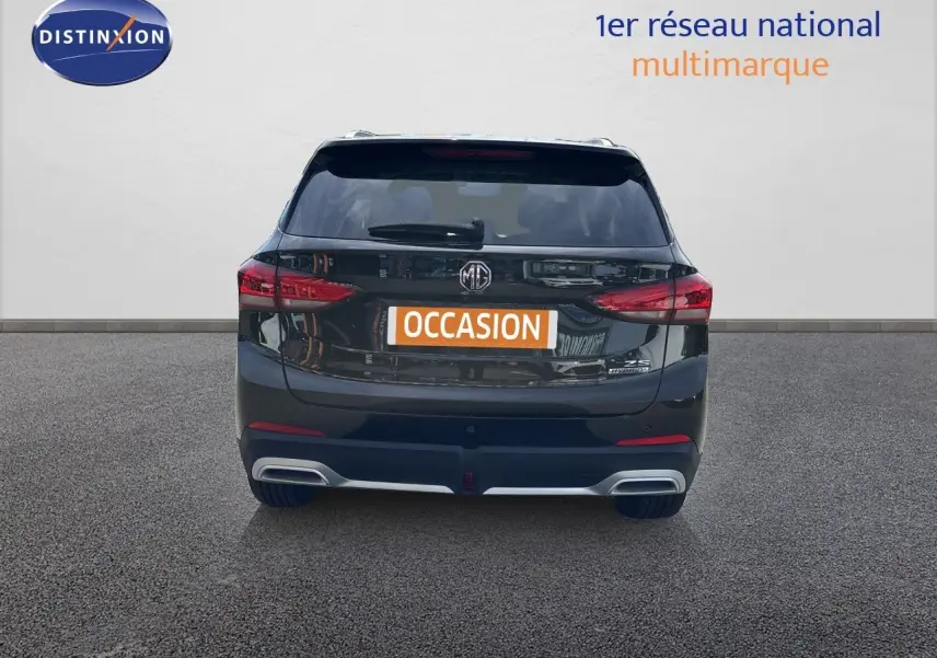 Vue arrière d’un MG MOTOR ZS 1.5L HYBRID+ 197CH LUXURY noir Pebble Black Metal avec feux LED et double sortie d’échappement.