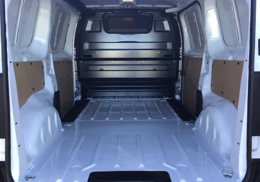 Vue intérieure arrière du fourgon blanc Peugeot Expert 2024 montrant l'espace de chargement vide et les parois latérales renforcées.