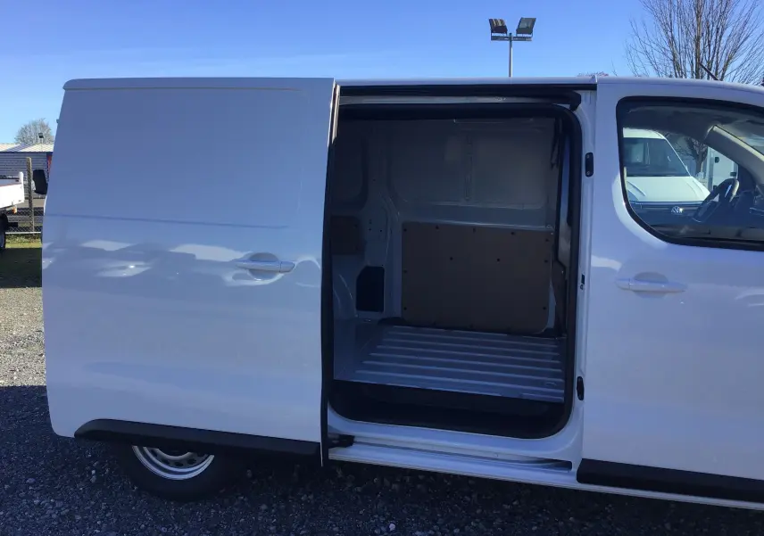Vue latérale droite d'un Peugeot Expert Fourgon blanc 2024 avec porte coulissante ouverte montrant l'espace de chargement vide.