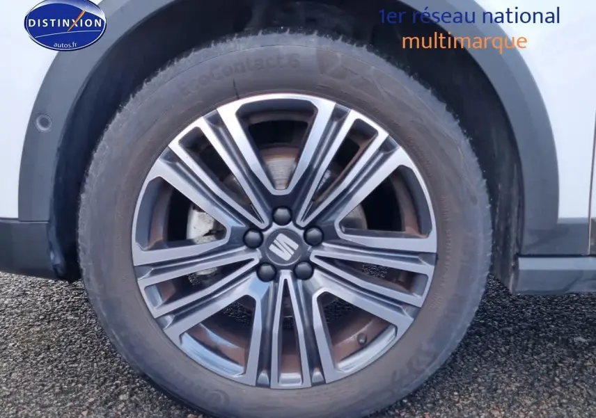 Gros plan sur la jante alu 17 pouces côté avant droit d'un SEAT Arona blanc 2023, mettant en valeur le logo central.