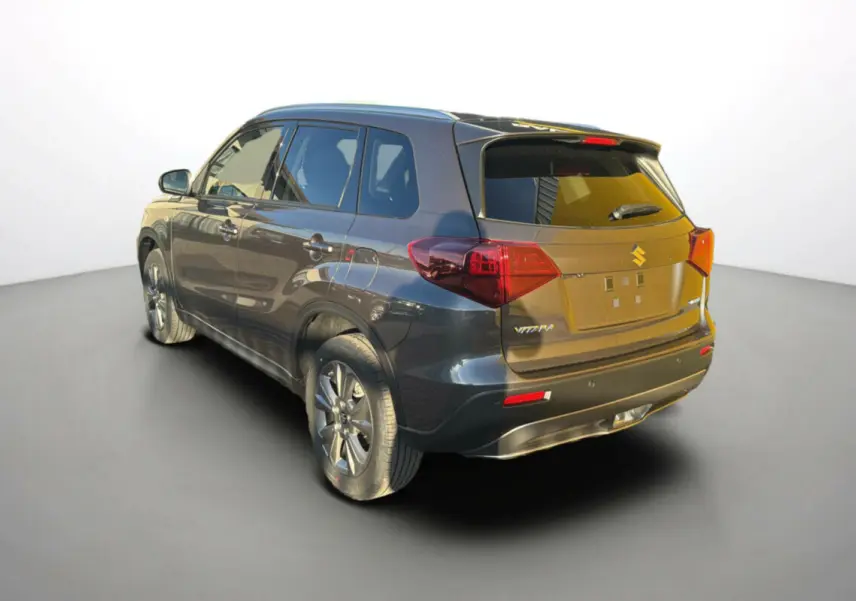 Suzuki Vitara 2025 gris titan en 3/4 arrière droit, avec feux arrière rouges et jantes alliage visibles.