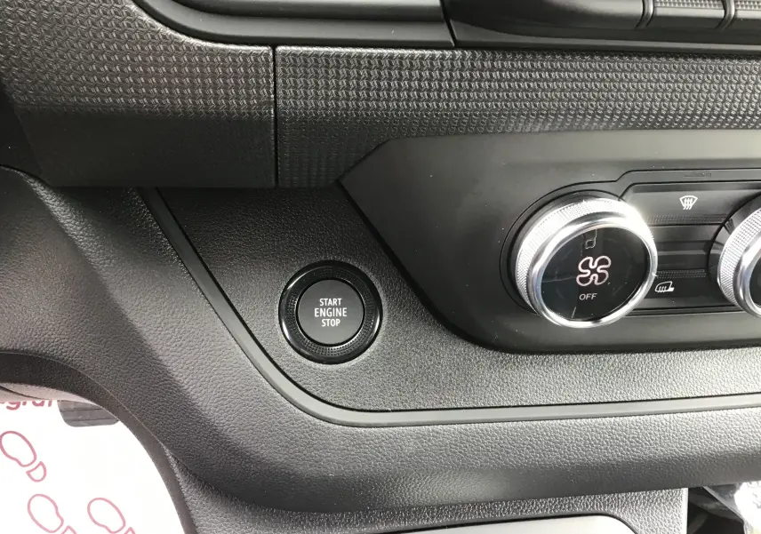 Détail intérieur montrant le bouton Start Engine Stop et les commandes de climatisation du Renault Trafic Fourgon gris Comète.