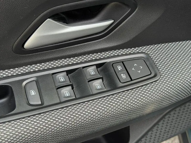 Gros plan sur les commandes des vitres électriques et rétroviseurs sur la porte côté conducteur du Dacia Jogger 2025.