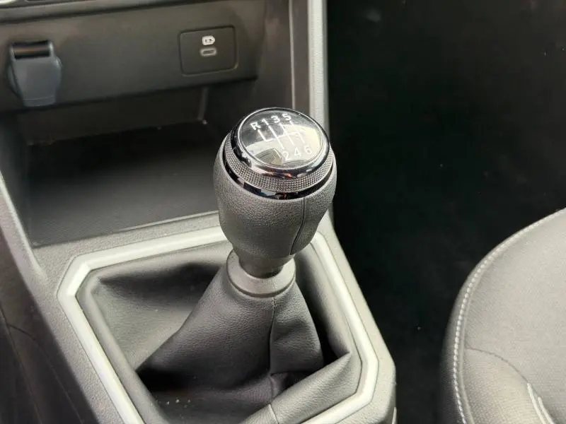 Gros plan sur le levier de vitesses manuel du Dacia Jogger 2025, entouré de garnitures noires et grises, intérieur sobre.