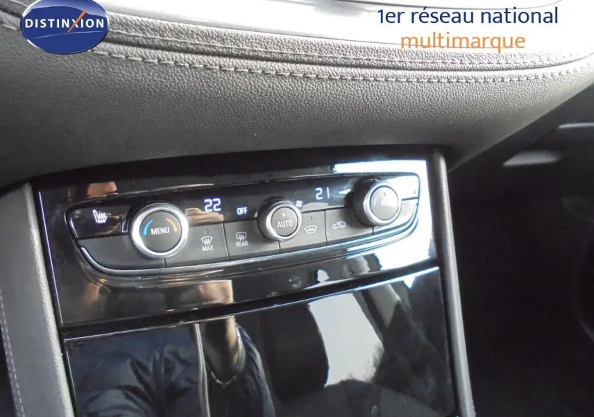 Gros plan sur la console centrale du Grandland X 2021, mettant en valeur les commandes de climatisation et les finitions noires brillantes.