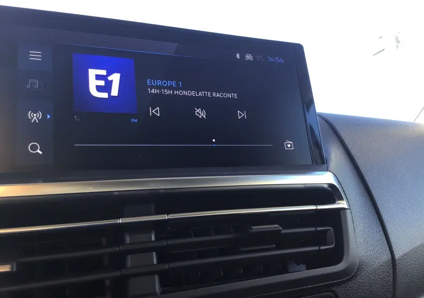 Écran tactile central du Peugeot Expert Fourgon 2024 affichant la radio Europe 1, avec la console noire et les aérateurs visibles.