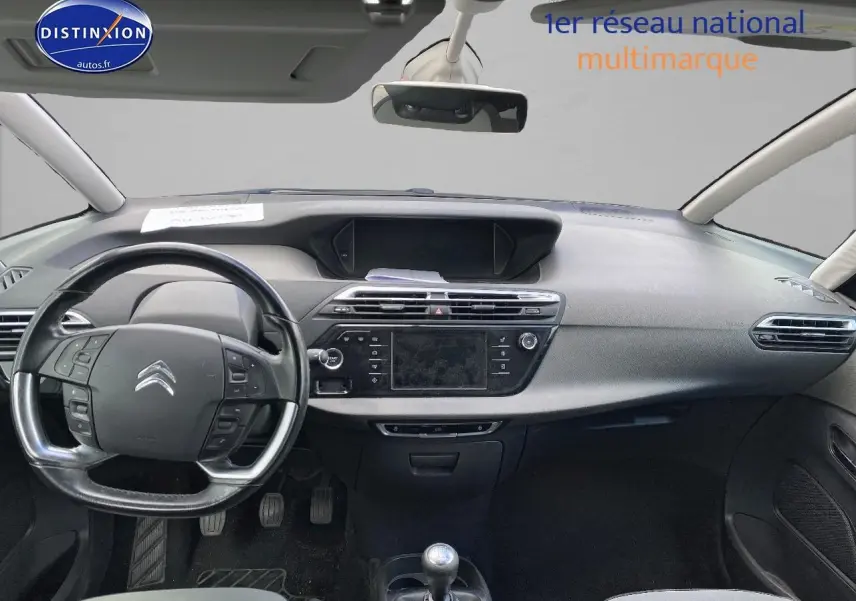 Intérieur avant d'une Citroën C4 Picasso gris, volant multifonction et tableau de bord avec écran tactile central.