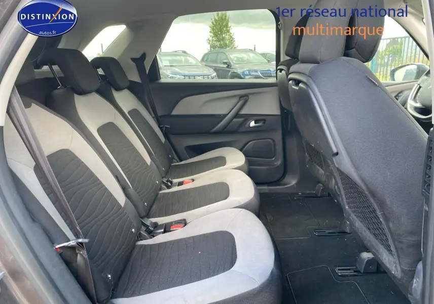 Vue intérieure de la deuxième rangée de sièges individuels gris et noir du Citroën C4 Picasso 2016 côté gauche.