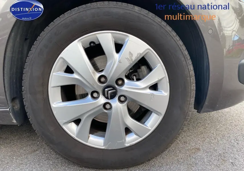 Gros plan sur la roue avant droite grise d'une Citroën C4 Picasso BlueHDi 120 intensive de 2016.