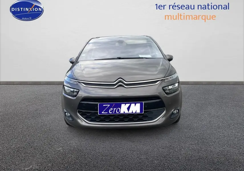 Vue frontale d'une Citroën C4 Picasso gris métallisé avec phares et calandre caractéristiques visibles.