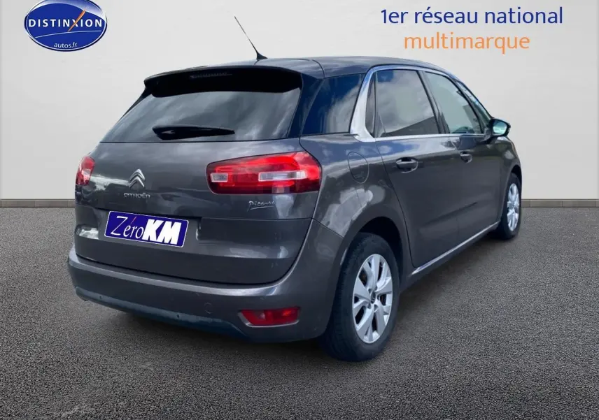 Citroën C4 Picasso gris vue 3/4 arrière droit, avec vitres teintées et jantes alliage visibles.