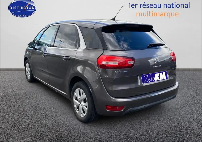 Vue 3/4 arrière droite d'une Citroën C4 Picasso gris métallisé avec vitres teintées et jantes alu.