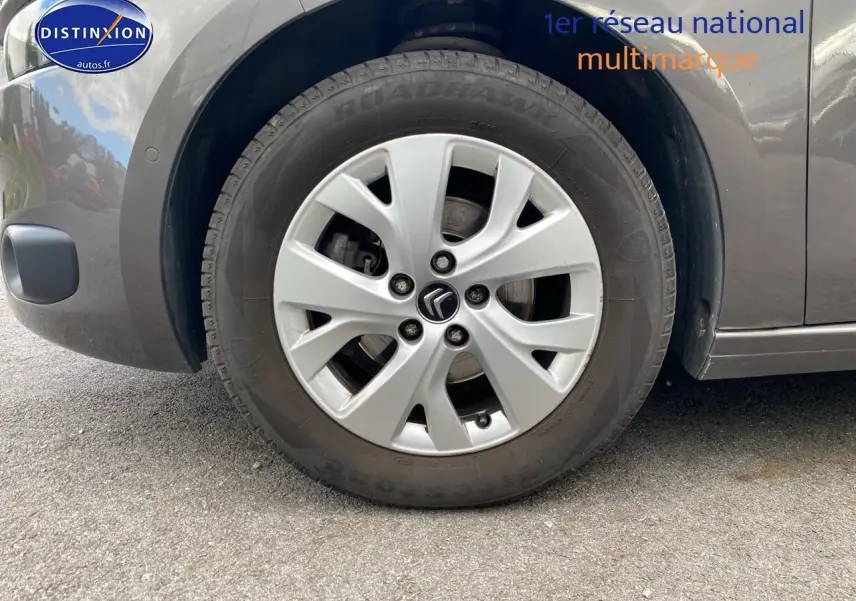 Gros plan sur la roue avant gauche grise d'une Citroën C4 Picasso BlueHDi 120 intensive de 2016.