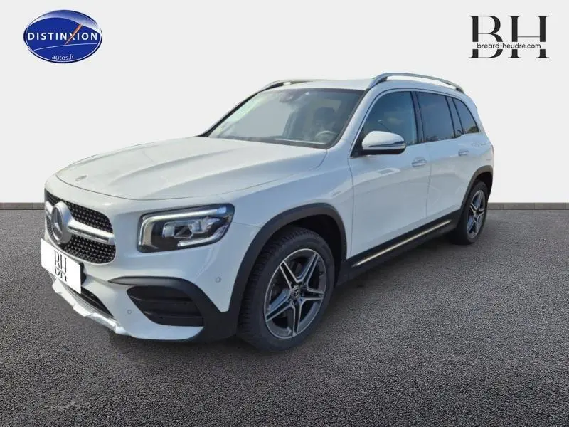 Mercedes GLB 200 d AMG Line blanc polaire vu en 3/4 avant droit avec jantes alliage et barres de toit noires