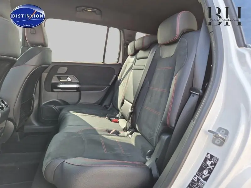 Vue latérale droite de la banquette arrière en similicuir noir avec surpiqûres rouges du Mercedes GLB blanc polaire 2023 AMG Line.