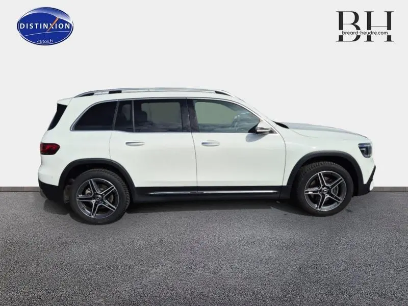 Profil côté droit d'un Mercedes GLB blanc polaire 2023 avec jantes AMG et toit ouvrant panoramique.