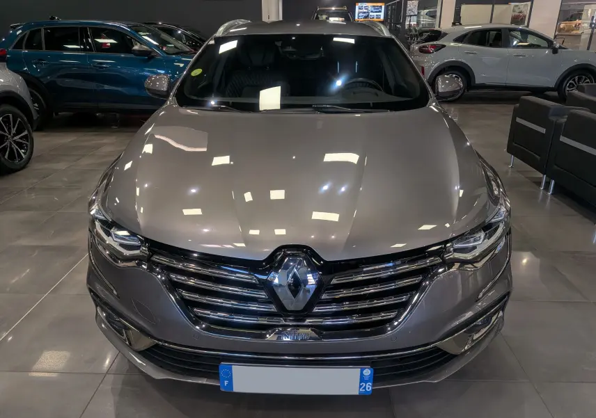 Vue frontale d'une Renault Talisman Estate gris Cassiopé, mettant en valeur sa calandre chromée et ses phares LED distinctifs.