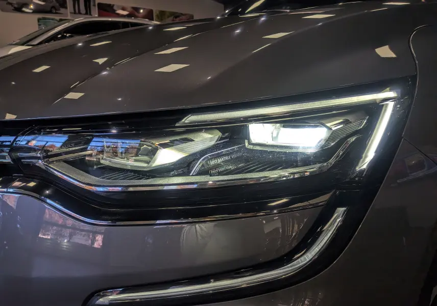 Gros plan sur le phare avant droit allumé de la Renault Talisman Estate gris Cassiopé, soulignant ses LED Matrix Vision.