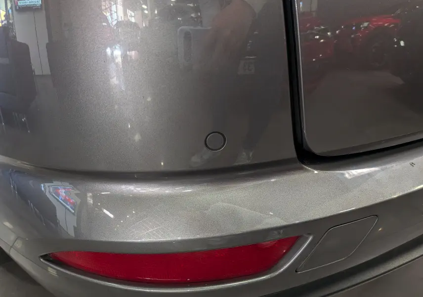 Gros plan sur le pare-chocs arrière gris Cassiopé d'une Renault Talisman Estate 2022 avec feu rouge et capteur de recul.