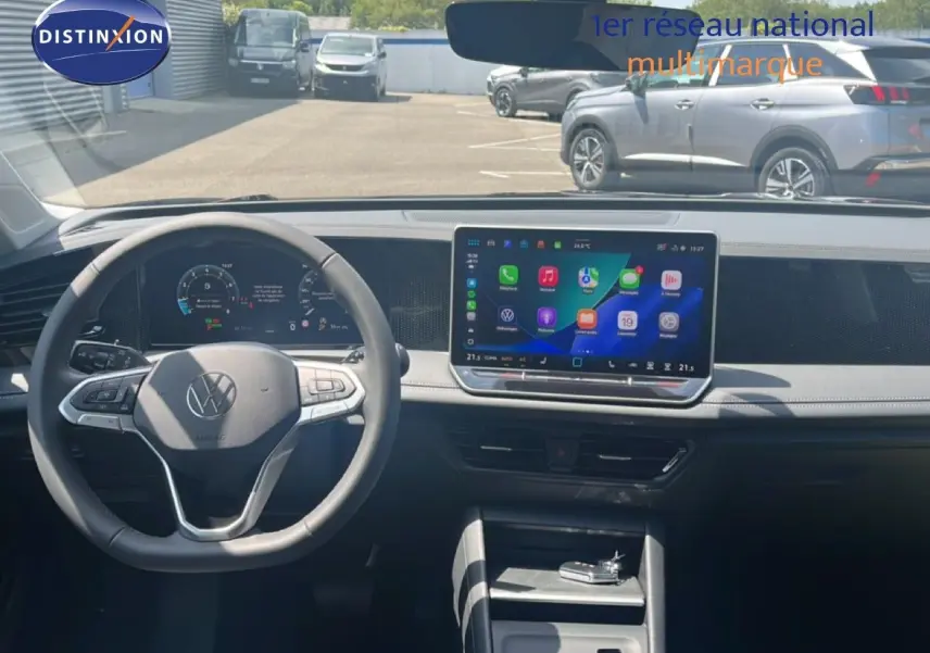 Vue intérieure du tableau de bord du Volkswagen Tiguan 2026 noir, avec écran tactile central et volant multifonction.