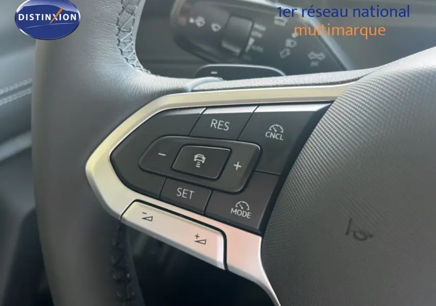 Gros plan sur les commandes au volant du Volkswagen Tiguan noir Grenadilla, mettant en valeur les boutons de régulateur de vitesse.